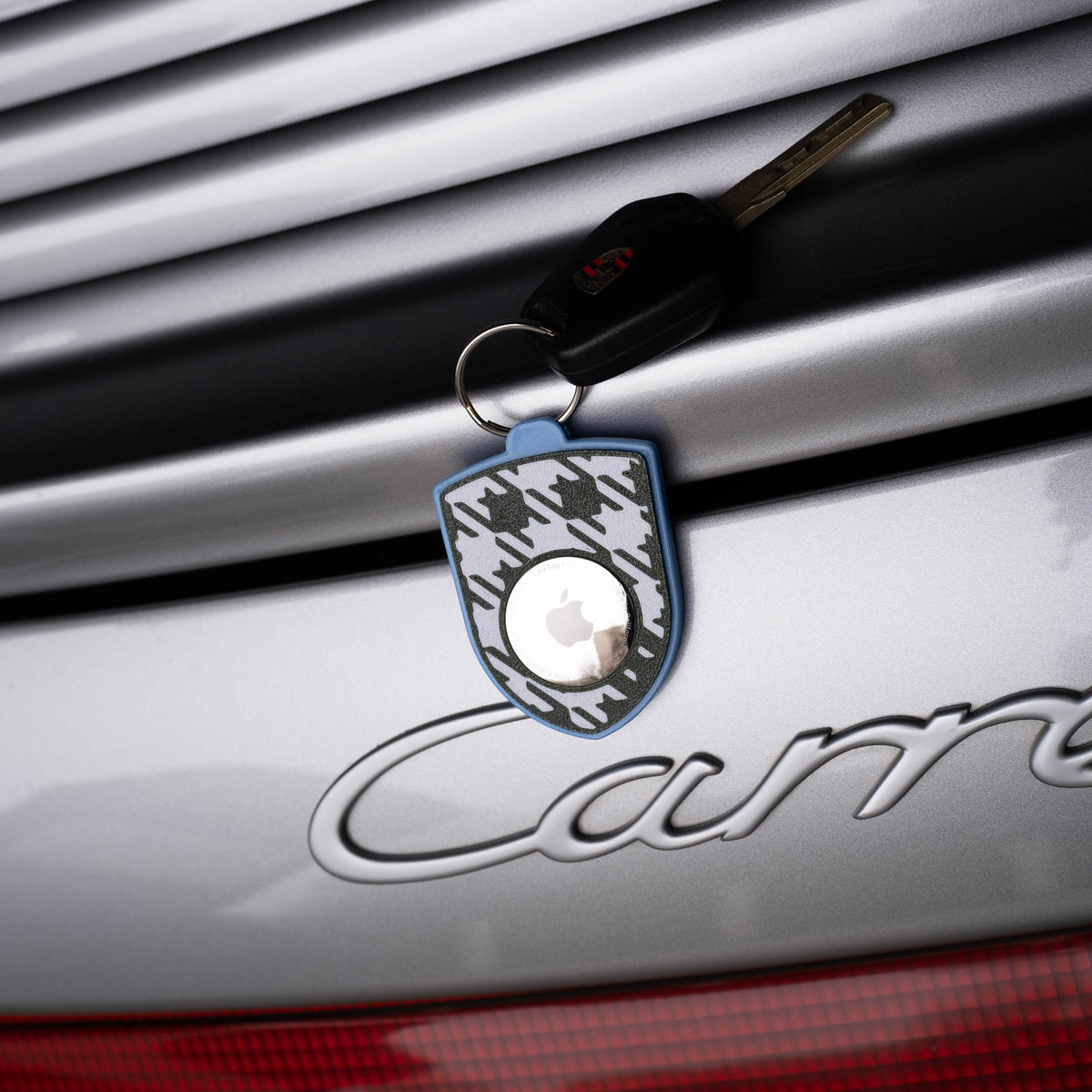 Blau-grüner AirTag-Schlüsselanhänger mit Pepita am Porsche Carrera
