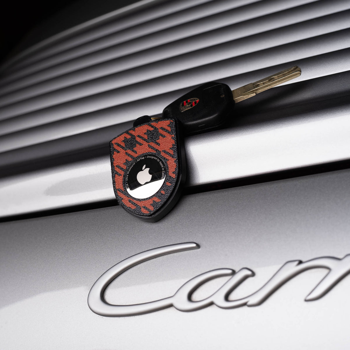 Schwarz-roter AirTag-Schlüsselanhänger mit Pepita am Porsche Carrera